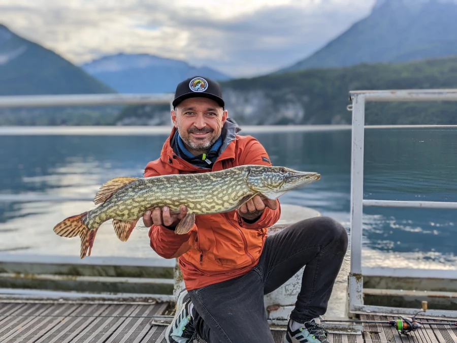 David Allary, moniteur guide de pêche en Auvergne, tenant un brochet qu'il vient de capturer en pêchant au leurre sur le lac d'Annecy