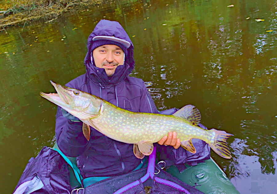 David Allary, moniteur guiode de pêche en Auvergne avec un brochet qu'il vient de capturer en float-tube