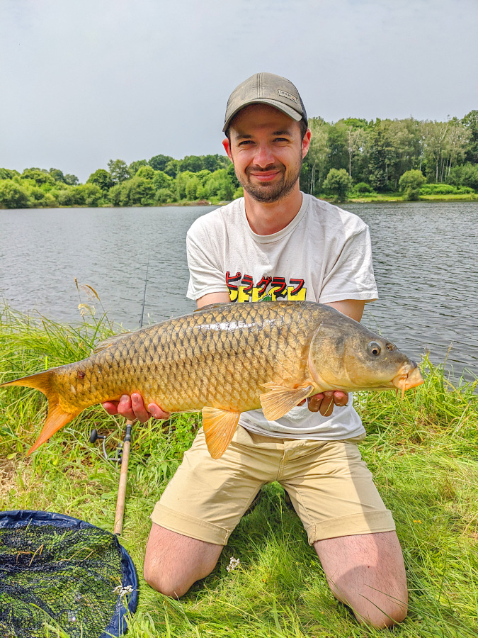 Tom avec une belle carpe prise aux côtés de DAvid Allary, Moniteur guide de pêche en Auvergne